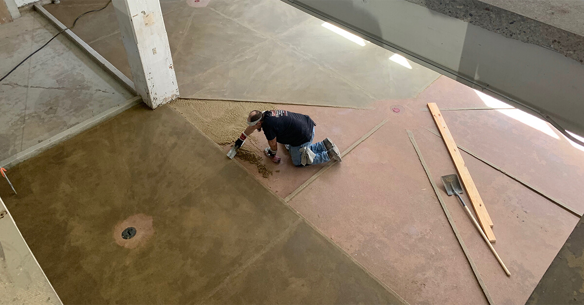 A resinous flooring installer slopes the floor to drains.