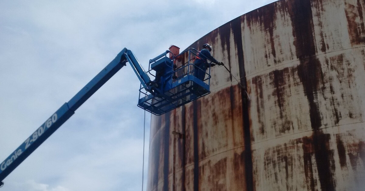 Surface preparation for overcoating on a storage tank.
