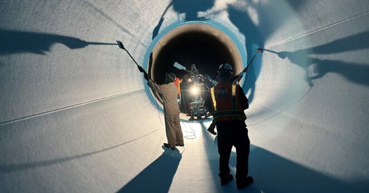 Workers use a rotary sprayer and rollers to apply a new lining on the Etiwanda Pipeline in Southern California.