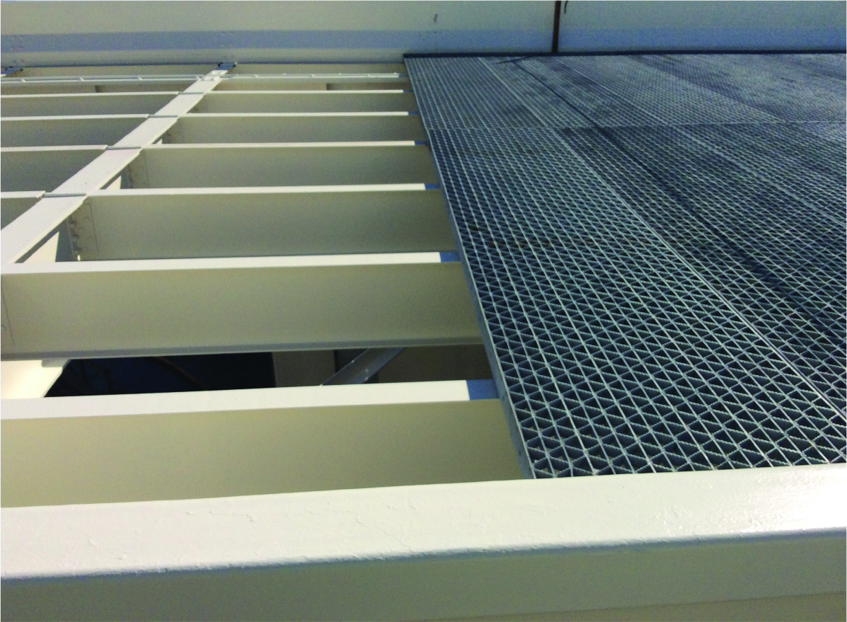 Fig. 5: New galvanized grating being installed over completed spans