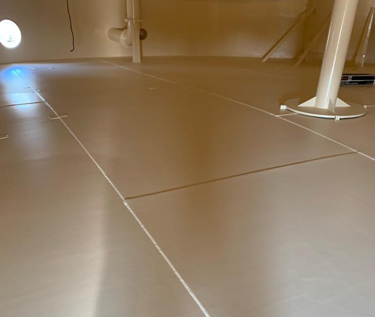 A picture of the interior surface of a potable water tank floor and wall.